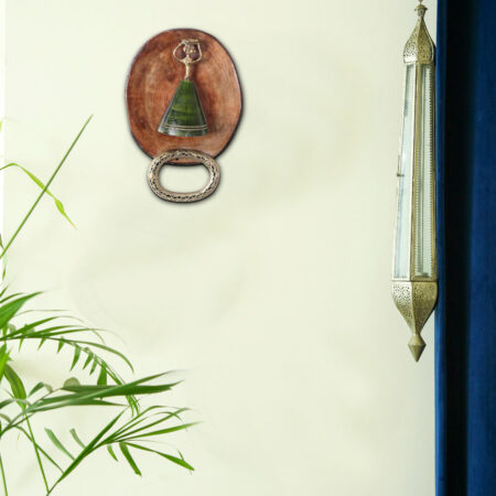 Dhokra Metal Towel Hanger on a pastel yellow wall with green fern plant